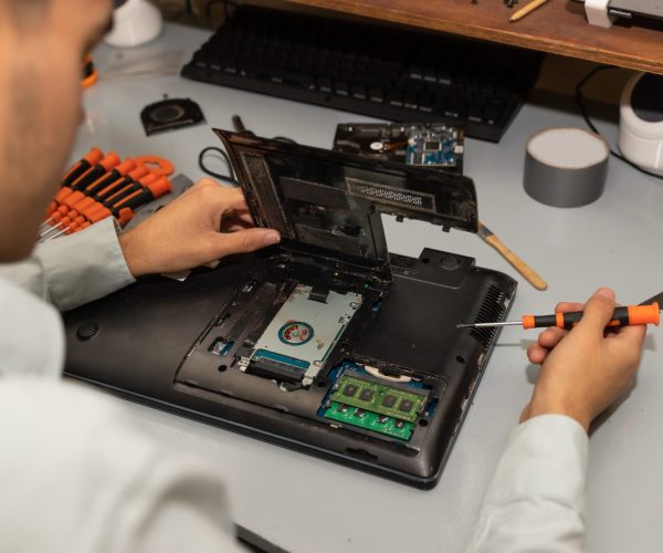 A computer repair technician repairing a laptop