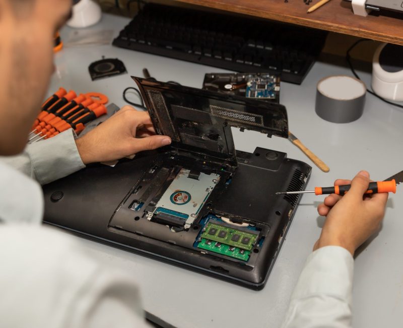 A computer repair technician repairing a laptop
